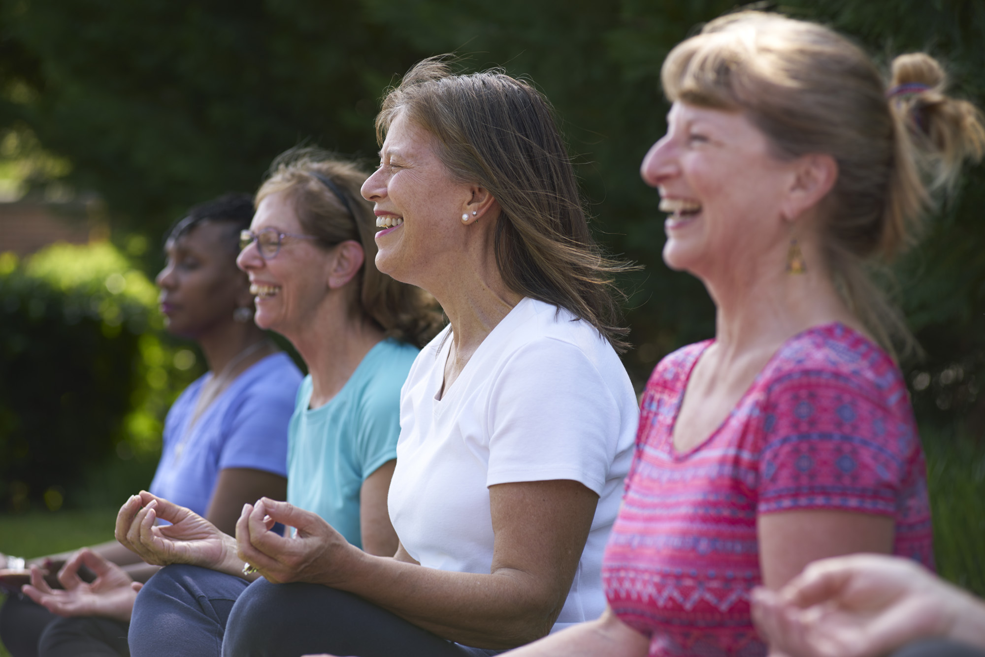 Women sit cross-legged in a meditation circle.