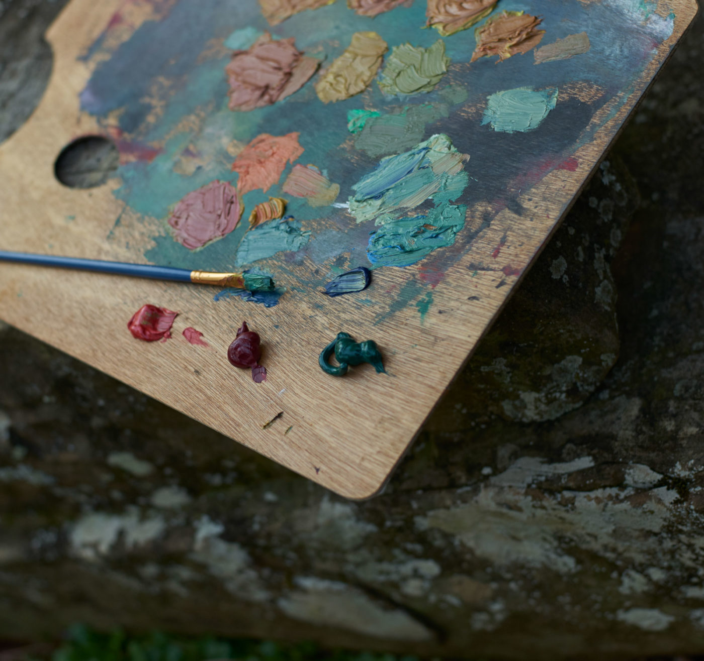 A close-up photo of oil paints on a wooden artist's palette.