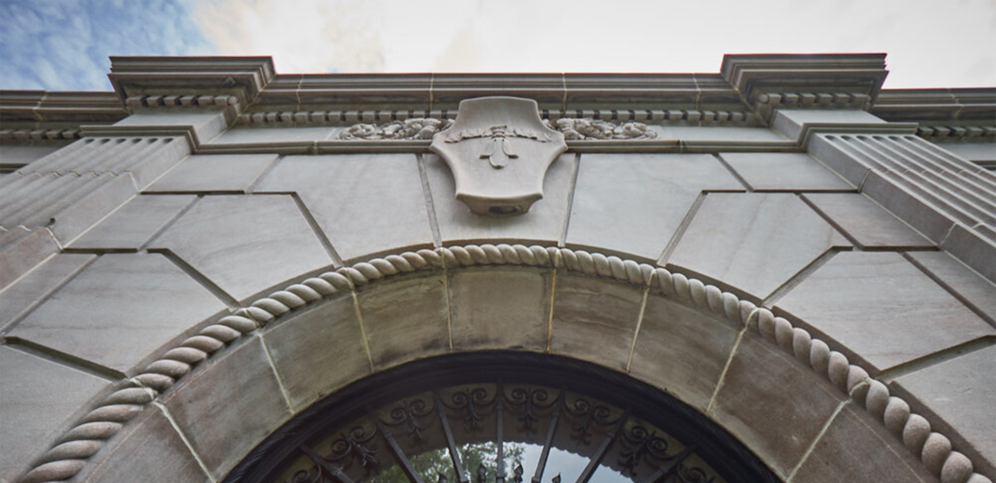 Looking up at the front entrance and carved marble crest of the Candoro Marble Building.