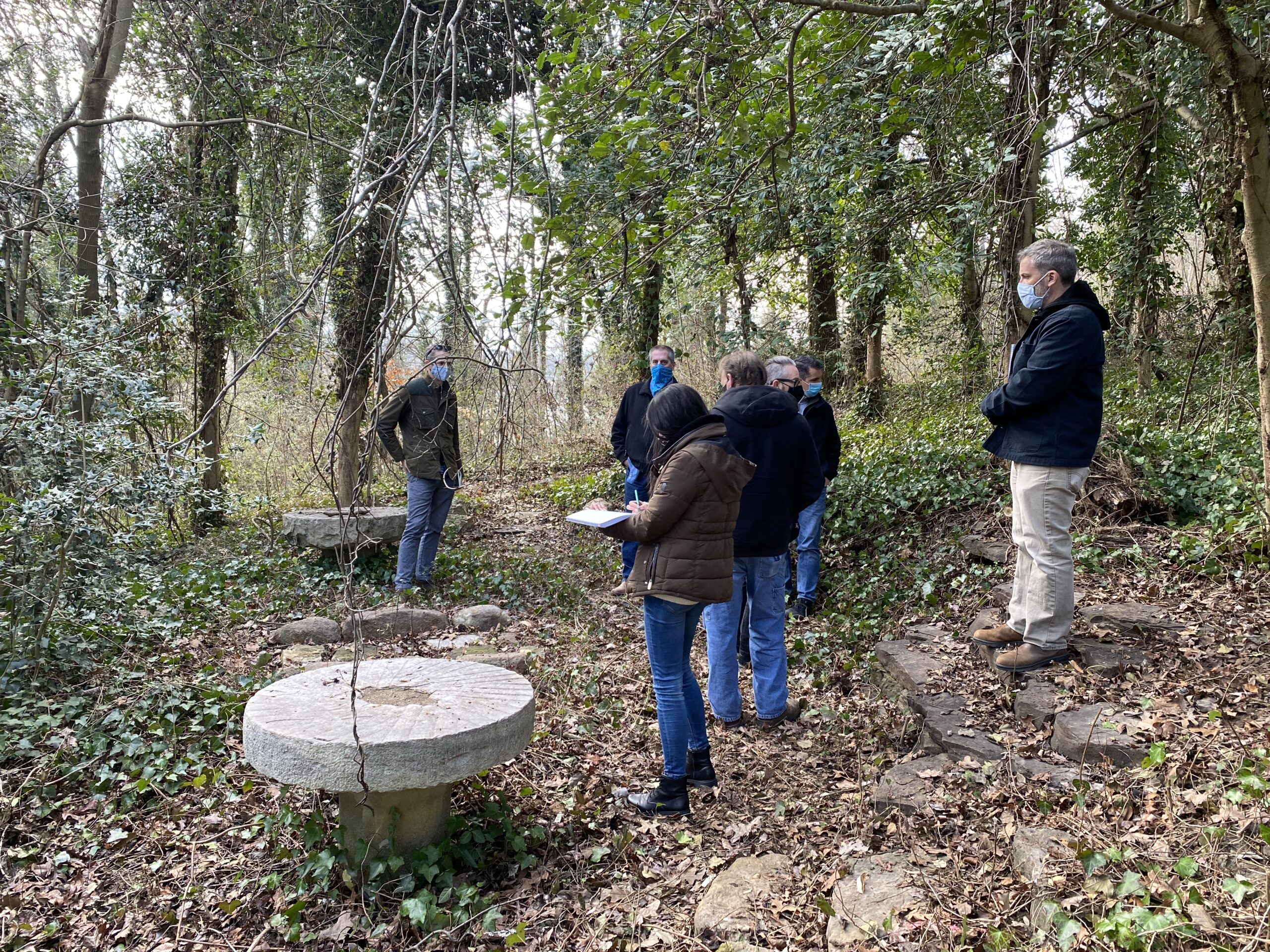 The architecture team gathers at the millstone tables in the woods behind the Eugenia Williams House.